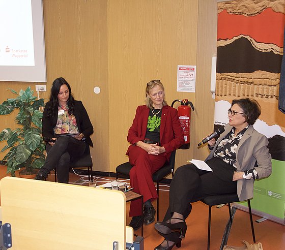 Gesprächssituation in einem Hörsaal. Auf dem Podium sitzen v.l.n.r. Sophie Charlott Ebert (Leiterin der Stabsstelle Gleichstellung und Vielfalt), Rektorin Birgitta Wolff und Prorektorin für nachhaltige Organisationsentwicklung und Diversität Rita Casale. 